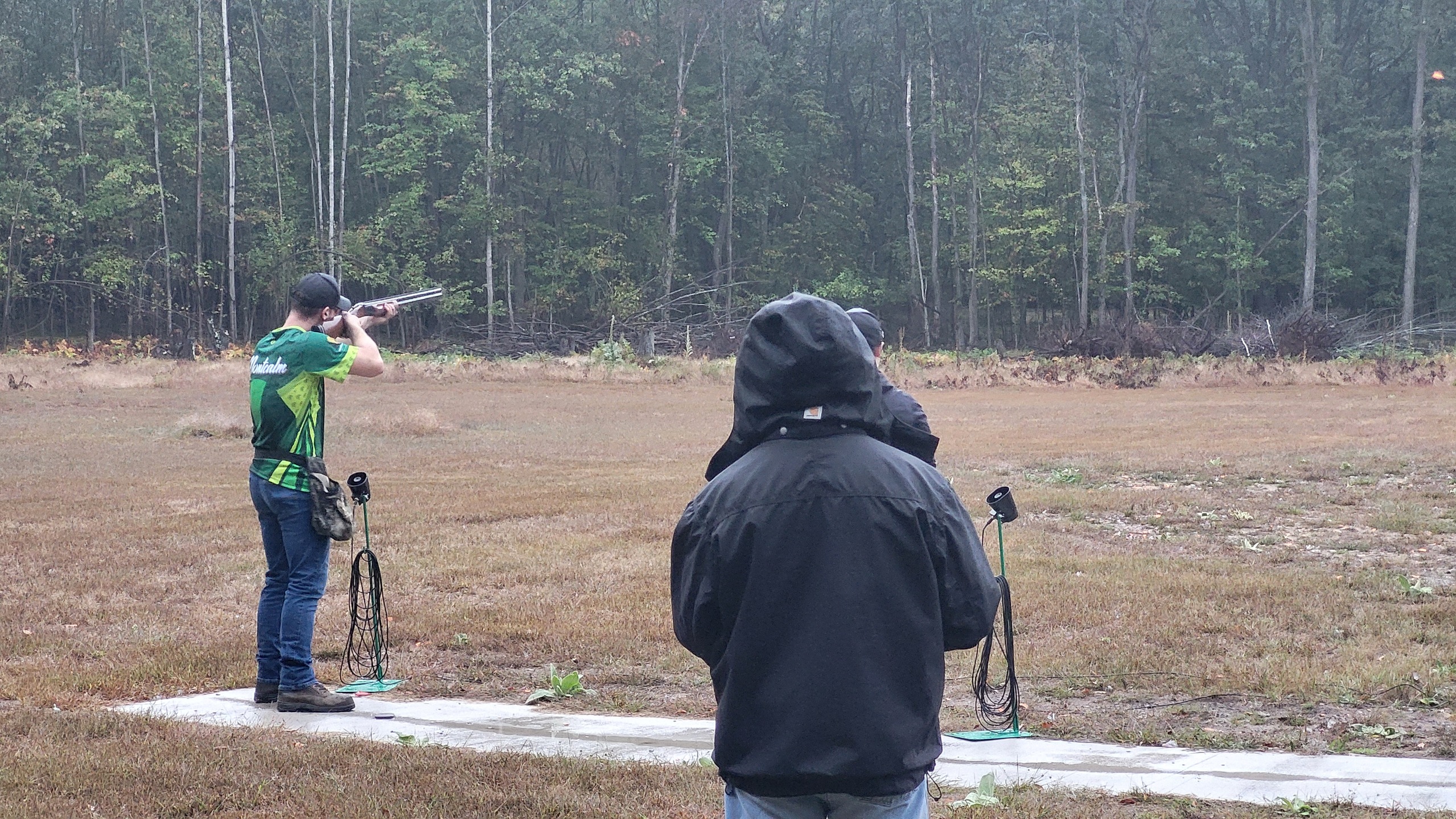 MCC clay target shooter aimming gun at a clay pigeon. 