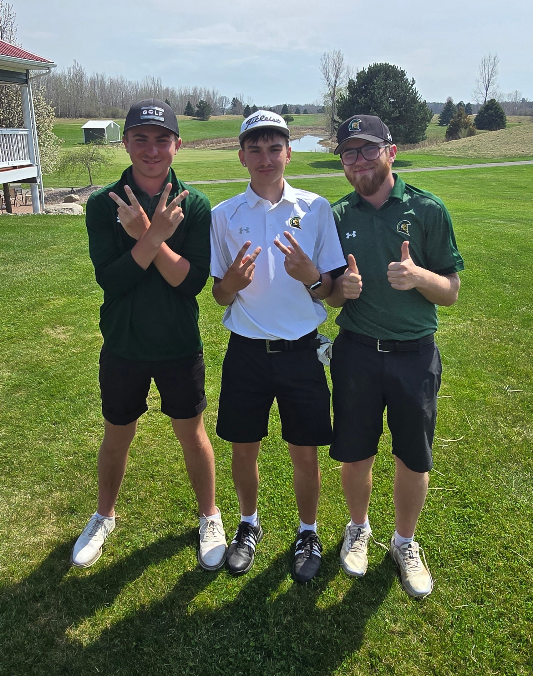 Johnson brothers and Mason Blair pose for a photo on the golf course.