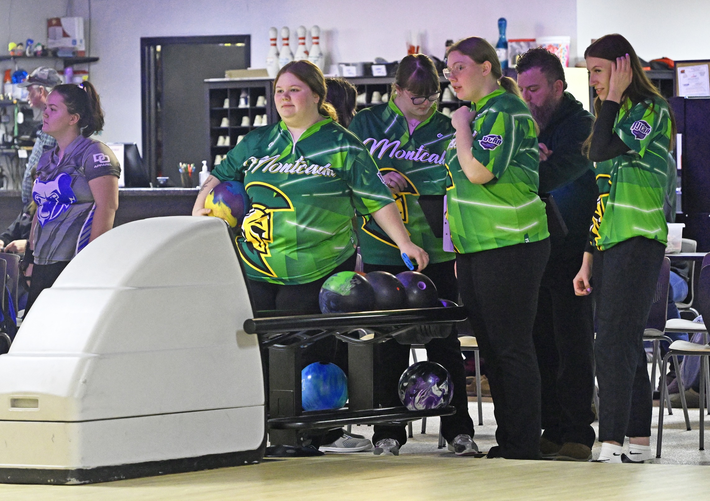 Group of MCC bowlers gathered around the lane.