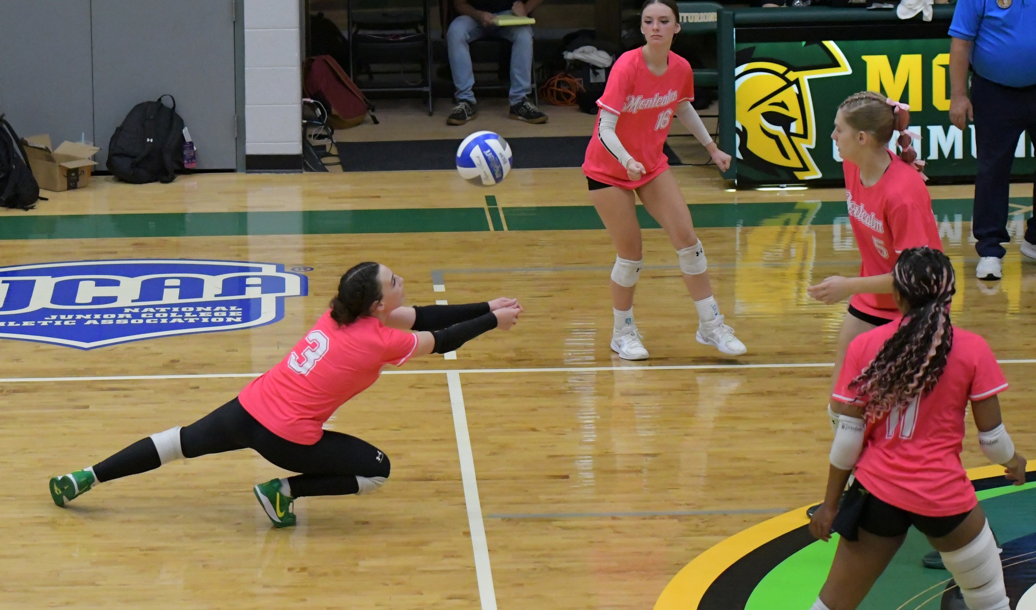 MCC volleyball player diving to hit an incoming ball on the court.